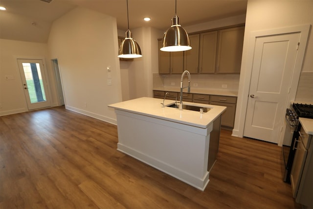 kitchen with sink, stainless steel gas stove, tasteful backsplash, hanging light fixtures, and a center island with sink