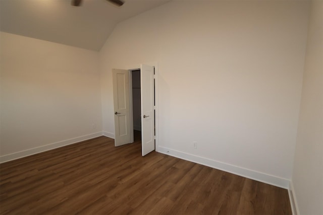 spare room featuring dark hardwood / wood-style flooring, vaulted ceiling, and ceiling fan