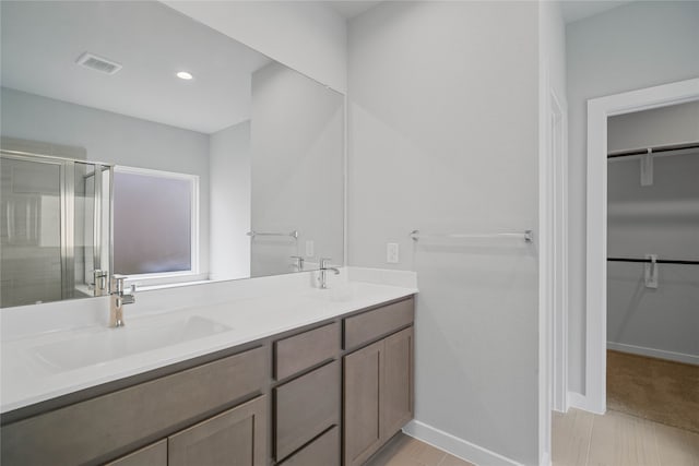 bathroom featuring vanity and a shower with shower door