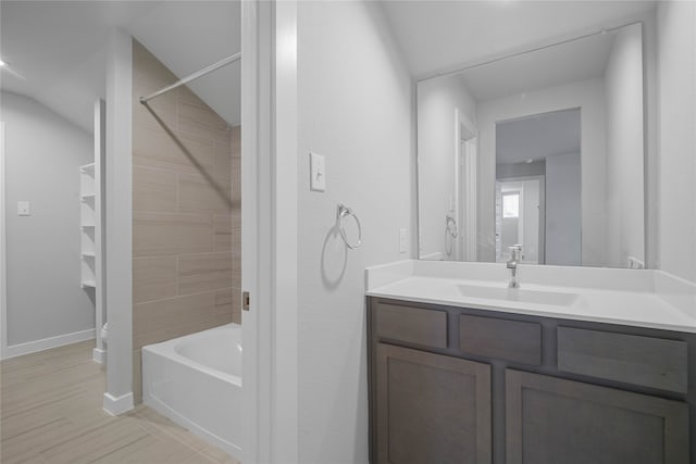 bathroom featuring vanity, wood-type flooring, and tiled shower / bath