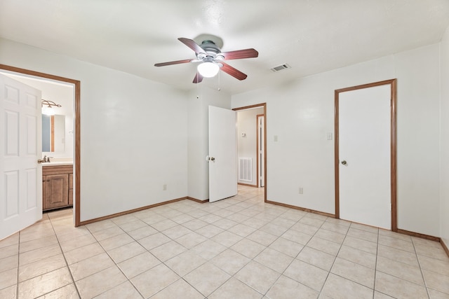 unfurnished bedroom with sink, ensuite bath, light tile patterned floors, and ceiling fan