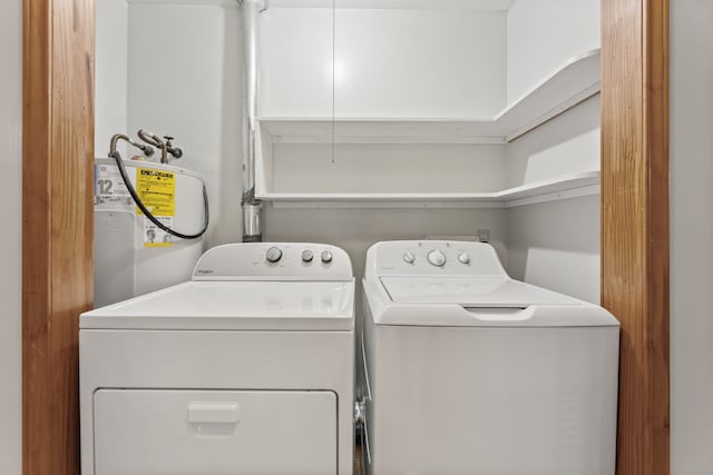 washroom with electric water heater and washing machine and dryer