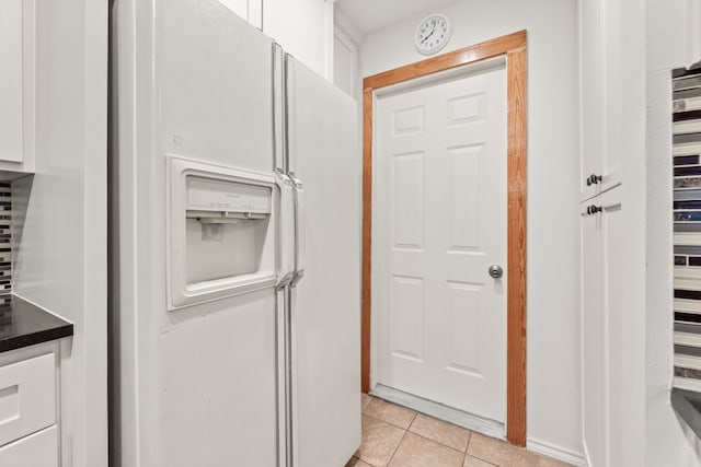 kitchen featuring white fridge with ice dispenser, white cabinets, and light tile patterned flooring