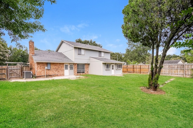 rear view of house featuring a lawn and central air condition unit