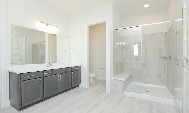 bathroom with vanity, toilet, and a shower with shower door