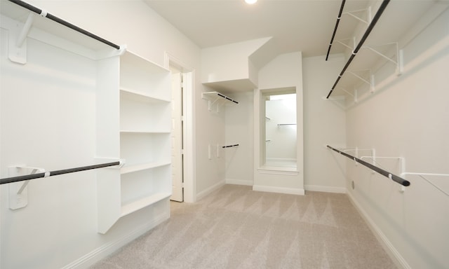 walk in closet featuring light carpet