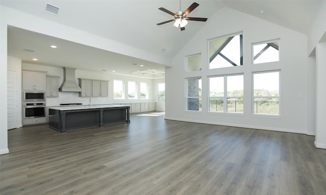 unfurnished living room with dark hardwood / wood-style floors, high vaulted ceiling, and ceiling fan