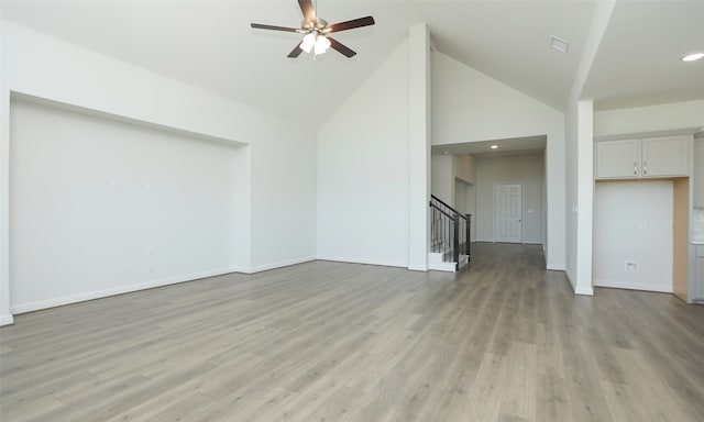 unfurnished living room with light wood-type flooring, high vaulted ceiling, and ceiling fan