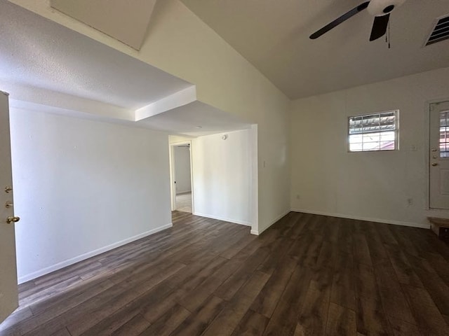 spare room with a textured ceiling, ceiling fan, dark hardwood / wood-style flooring, and vaulted ceiling