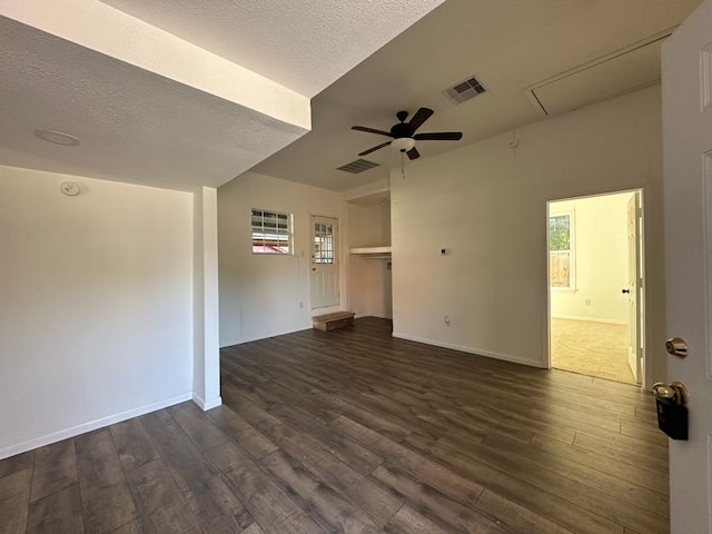 unfurnished living room with a textured ceiling, ceiling fan, and dark wood-type flooring