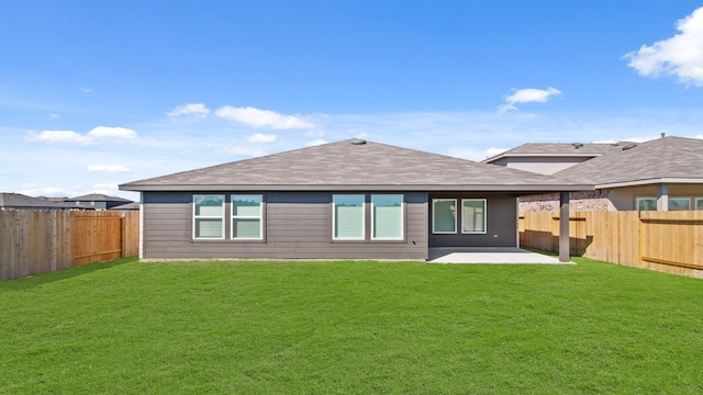 rear view of house featuring a yard and a patio