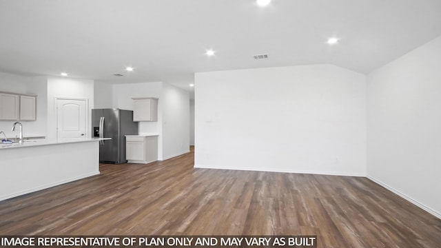 kitchen featuring gray cabinetry, sink, vaulted ceiling, dark hardwood / wood-style floors, and stainless steel fridge with ice dispenser