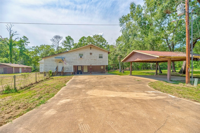 view of front of property featuring a front lawn and a carport