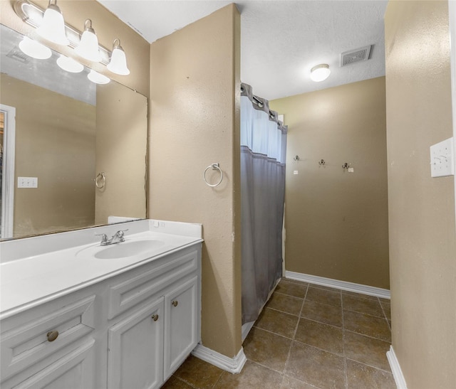 bathroom with a shower with curtain, vanity, and tile patterned flooring