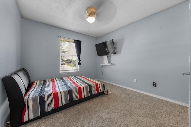 carpeted bedroom with ceiling fan and a textured ceiling