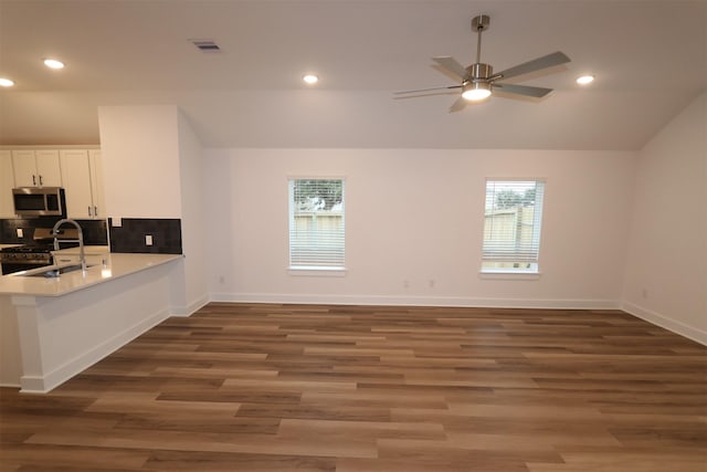 kitchen featuring white cabinetry, sink, dark hardwood / wood-style floors, vaulted ceiling, and appliances with stainless steel finishes