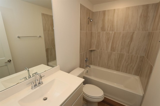 full bathroom featuring tiled shower / bath combo, toilet, and vanity