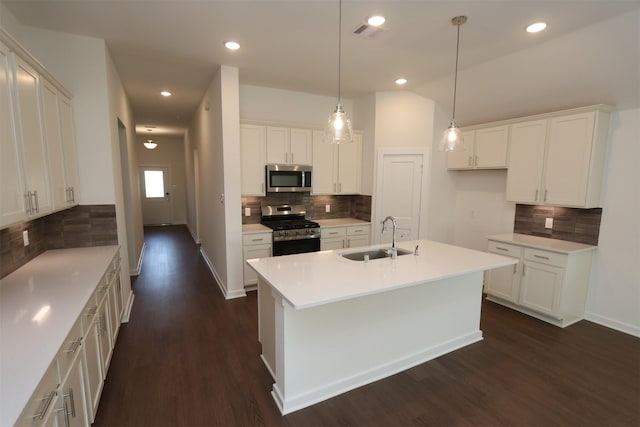 kitchen with sink, tasteful backsplash, dark hardwood / wood-style flooring, white cabinets, and appliances with stainless steel finishes