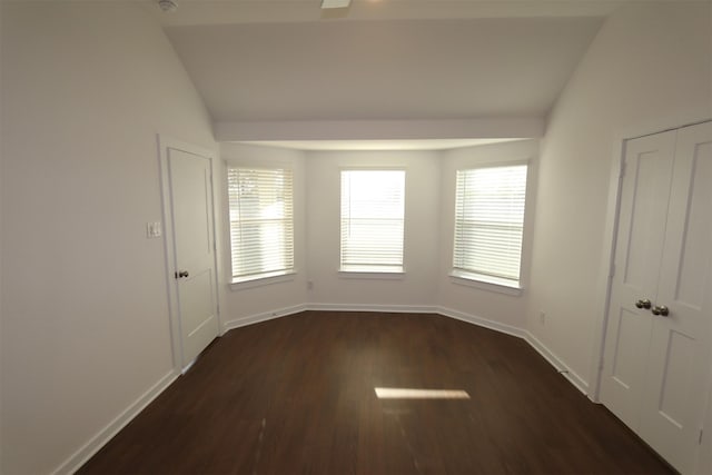 spare room featuring dark hardwood / wood-style flooring and vaulted ceiling