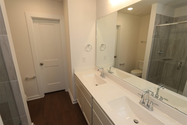 bathroom with an enclosed shower, vanity, toilet, and wood-type flooring