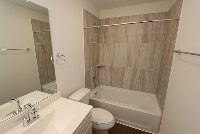 full bathroom featuring vanity, tiled shower / bath combo, and toilet