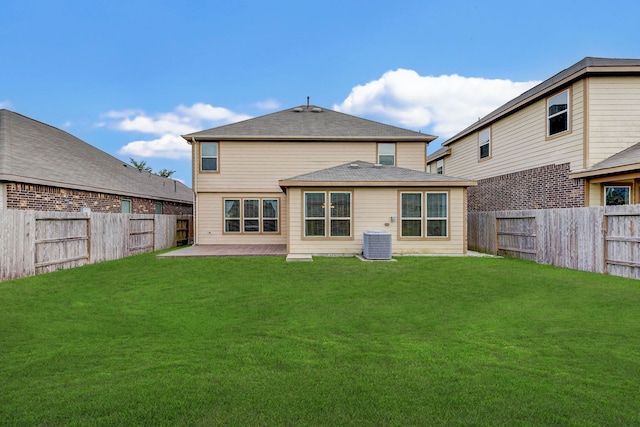 rear view of house with a lawn, cooling unit, and a patio