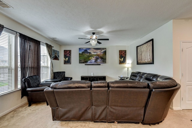 carpeted living room featuring a textured ceiling, plenty of natural light, and ceiling fan