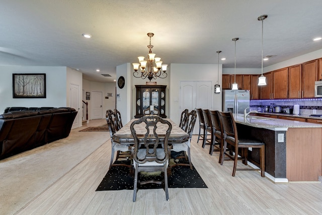 dining space with an inviting chandelier and light wood-type flooring