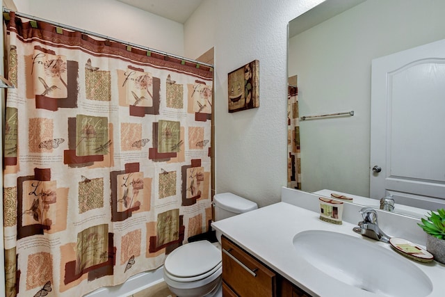 bathroom with walk in shower, vanity, and toilet