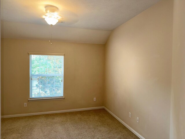 unfurnished room featuring carpet floors, lofted ceiling, and ceiling fan