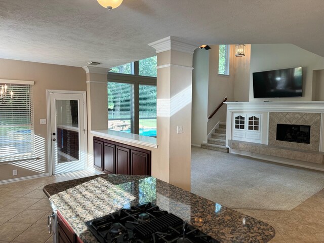 kitchen featuring light tile patterned flooring, a fireplace, and a textured ceiling