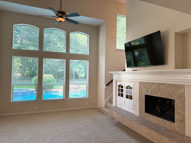 unfurnished living room featuring carpet flooring, a fireplace, and plenty of natural light