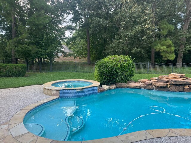 view of swimming pool with an in ground hot tub