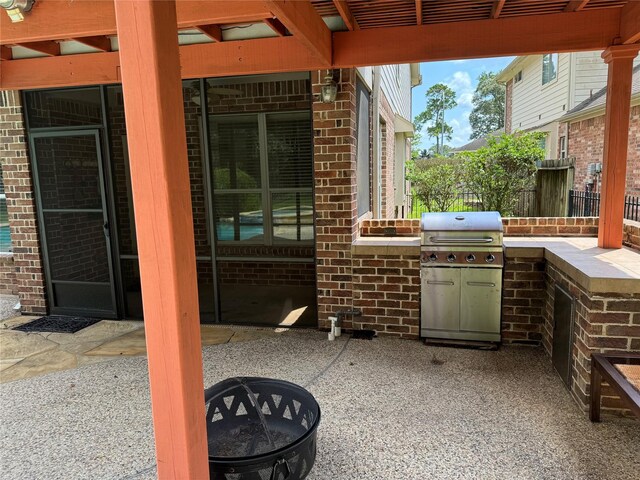 view of patio featuring an outdoor fire pit, grilling area, and a pergola