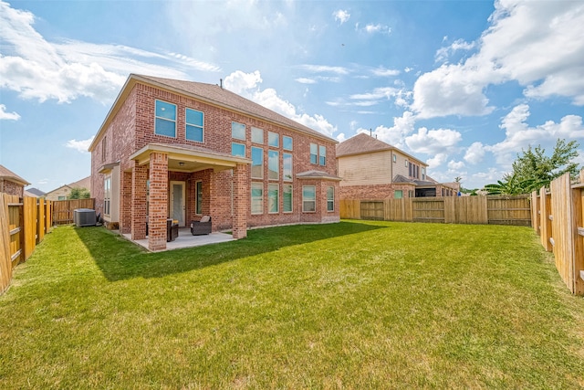 rear view of house with cooling unit, a yard, and a patio