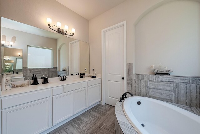 bathroom with tiled bath and vanity