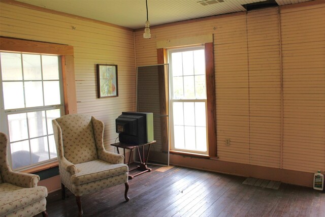 sitting room featuring wooden walls and hardwood / wood-style flooring