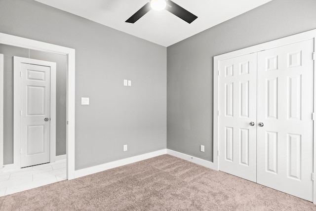 unfurnished bedroom featuring light colored carpet, ceiling fan, and a closet