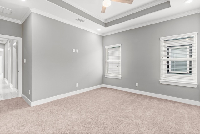 unfurnished room with crown molding, light colored carpet, a tray ceiling, and ceiling fan