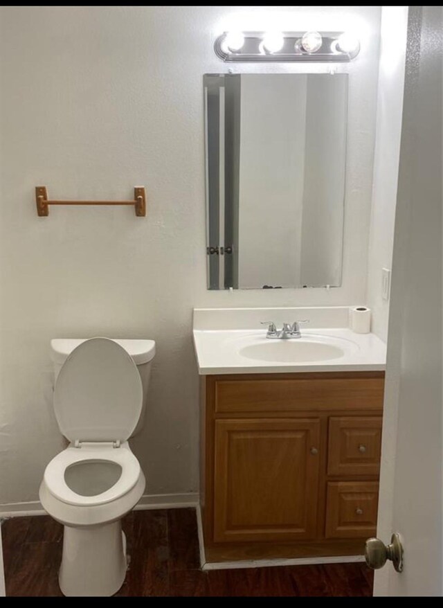 bathroom with vanity, wood-type flooring, and toilet