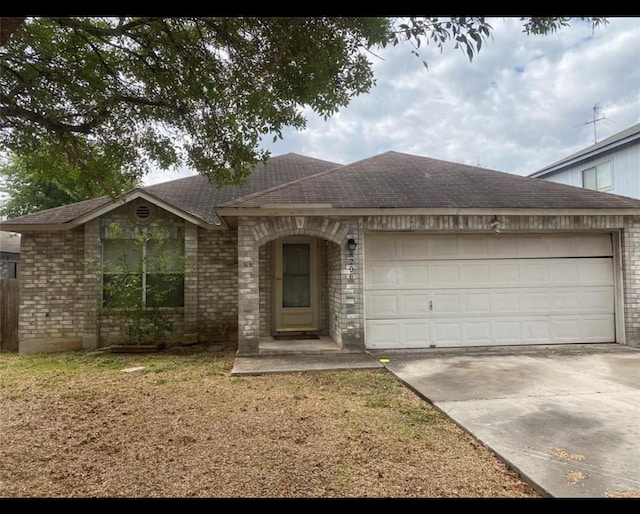 ranch-style house featuring a garage and a front lawn