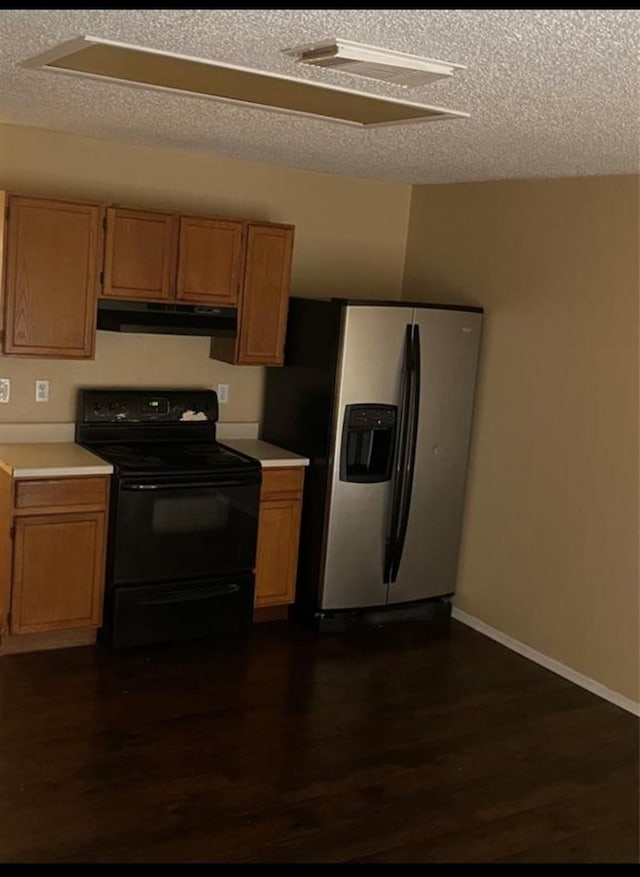 kitchen with black range with electric cooktop, stainless steel fridge, dark hardwood / wood-style floors, and a textured ceiling