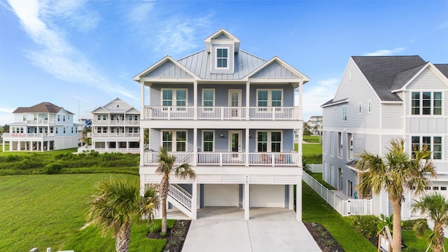 raised beach house with board and batten siding, a front yard, a standing seam roof, and metal roof