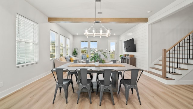 dining room featuring light wood finished floors, beam ceiling, a chandelier, and stairs