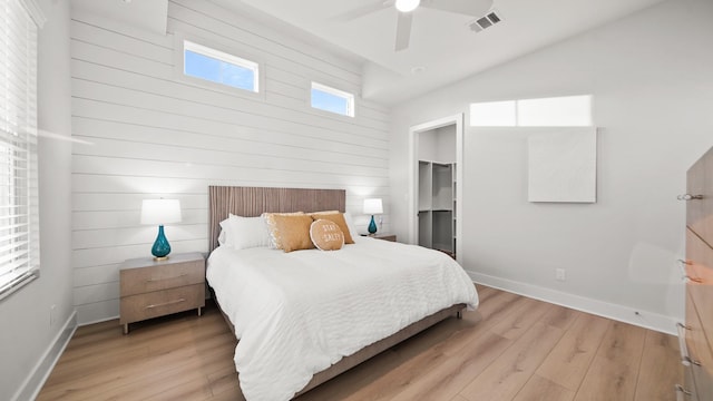 bedroom with light wood finished floors, visible vents, a spacious closet, ceiling fan, and baseboards