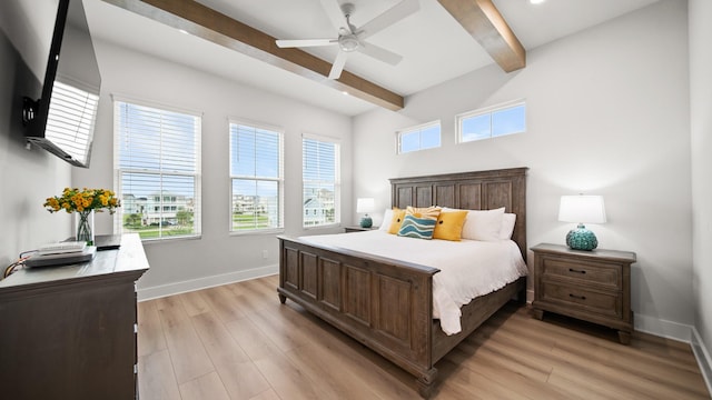 bedroom with beam ceiling, light wood-style floors, baseboards, and ceiling fan