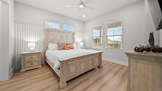 bedroom featuring multiple windows, a ceiling fan, and light wood finished floors