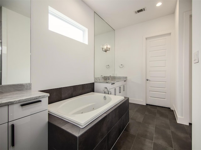 bathroom featuring vanity, tiled bath, and tile patterned floors