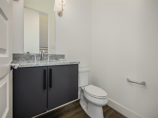 bathroom featuring vanity, hardwood / wood-style floors, and toilet