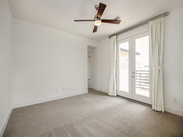 carpeted spare room with ceiling fan and french doors